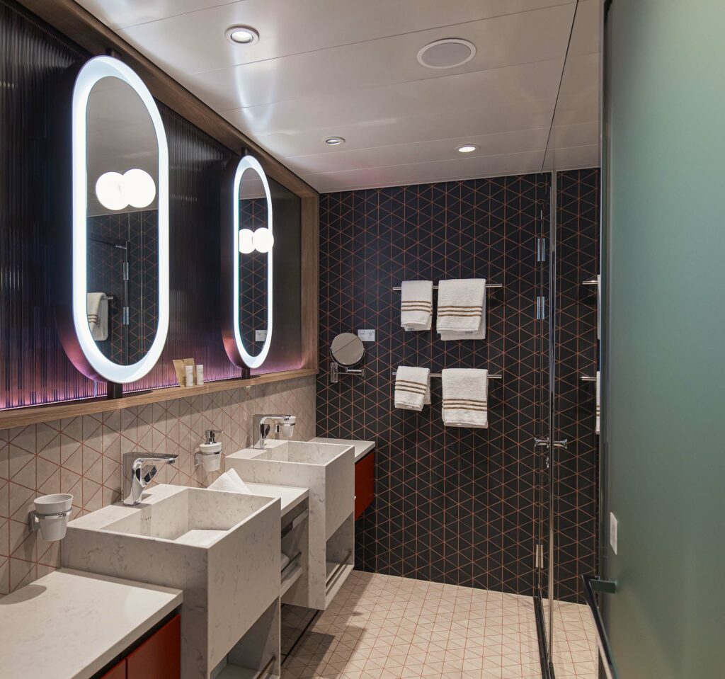 Interior of a wet unit module, black and cream color scheme with modern basins and round mirrors.